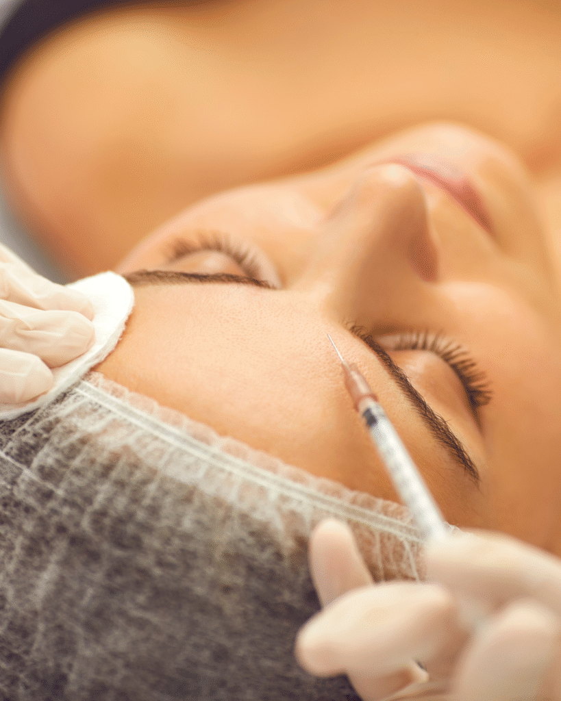 Une femme subit une injection de botox sur son front.