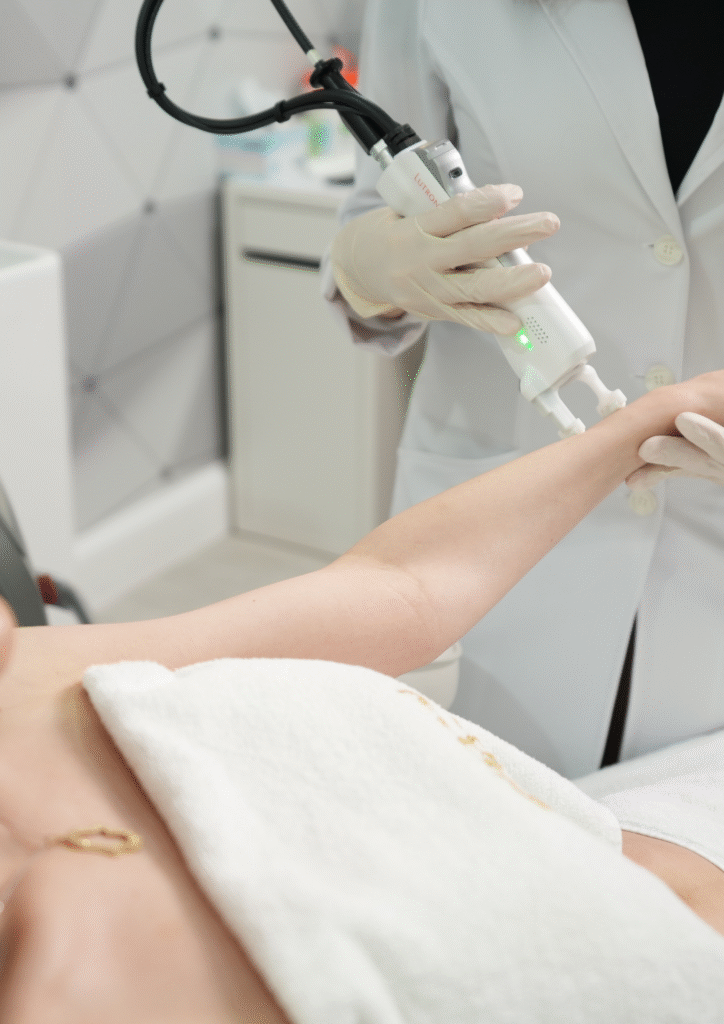 Séance d’épilation laser des bras réalisée par une praticienne en institut, utilisant un appareil professionnel sur l’avant-bras d’une patiente.